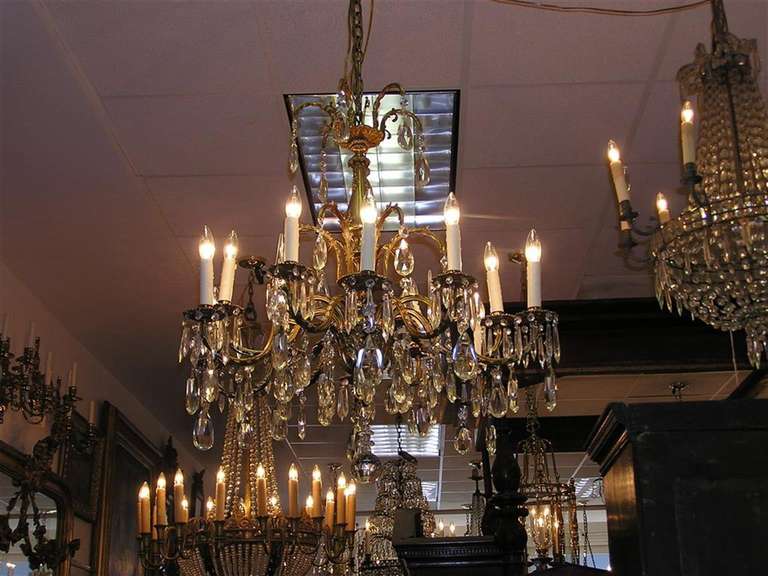 French brass & crystal twelve light chandelier with crystal spheres and floral motif. 19th Century. Originally candle powered and has been electrified.  