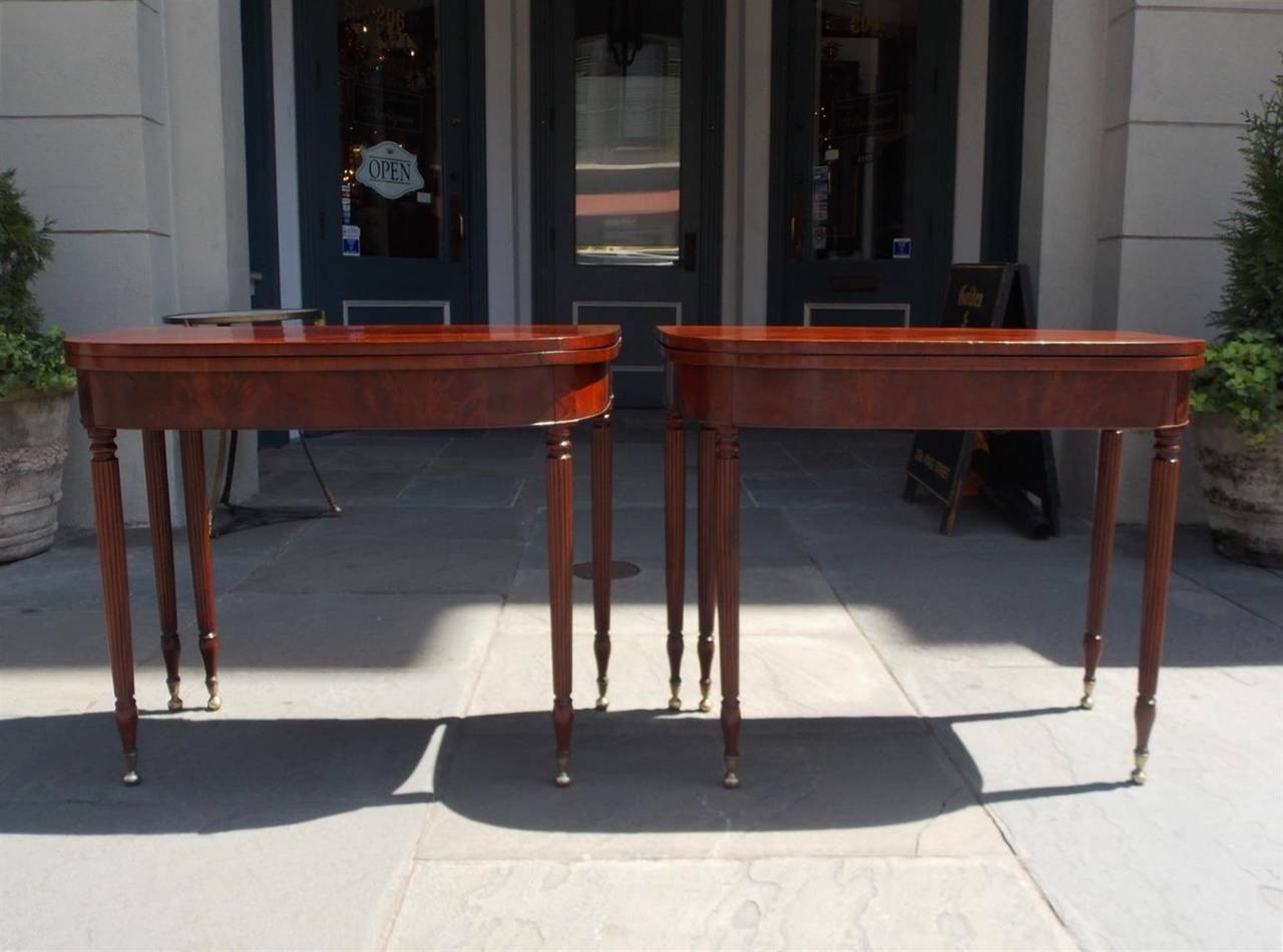 Pair of American Sheraton mahogany one board flip-top card tables with reeded bulbous legs and original brass ball casters. Tables have a gate leg to support tops when open. New York, Late 18th century.