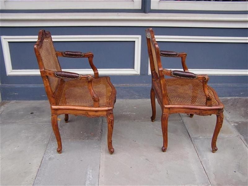 Tissu d'ameublement Paire de fauteuils français en noyer avec feuillage et coquillages et sièges en rotin, vers 1820  en vente