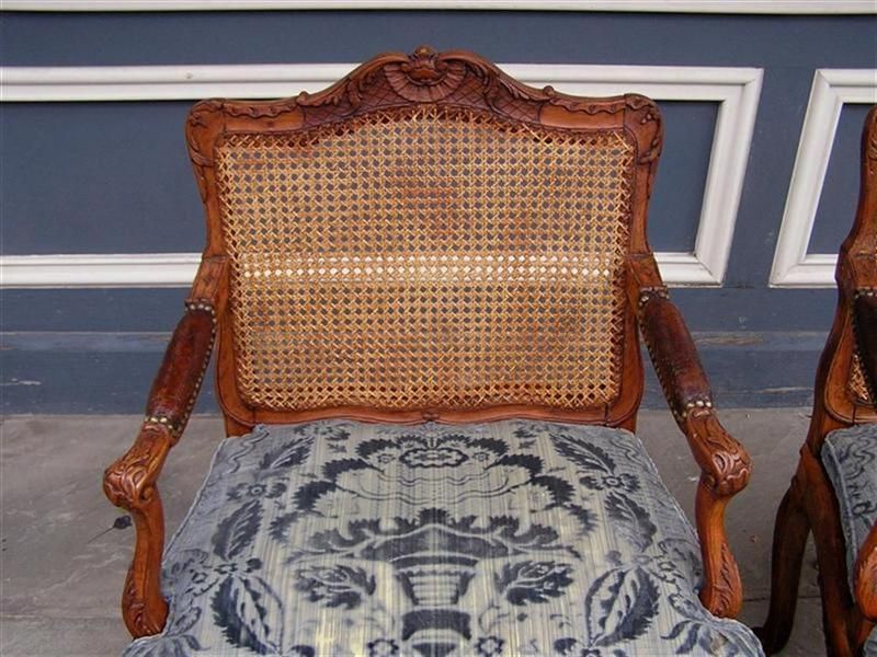 Français Paire de fauteuils français en noyer avec feuillage et coquillages et sièges en rotin, vers 1820  en vente