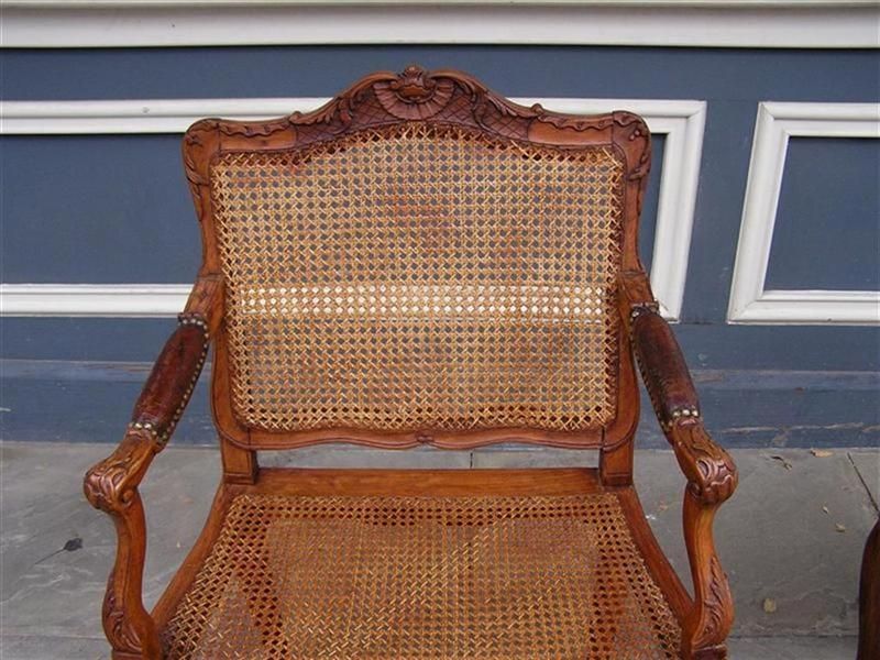 Early 19th Century Pair of French Walnut Foliage and Shell Arm Chairs with Cane Seats C. 1820  For Sale