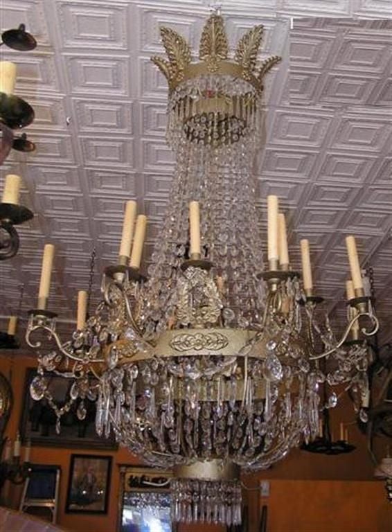 Zwei österreichische Regency-Kronleuchter mit sechzehn Lichtern aus vergoldeter Bronze mit filigranen Blättern und Medaillons aus Kristall. Ursprünglich wurden sie mit Kerzen betrieben und sind inzwischen elektrifiziert. Anfang 19. Jahrhundert