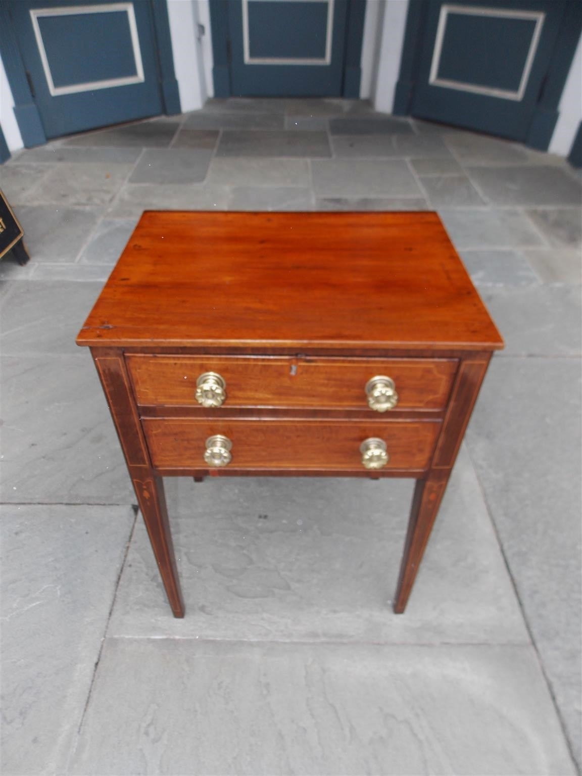 Charleston mahogany two-drawer side table with holly string inlay, dotted bell flowers, original brass floral knobs and terminating on squared tapered legs. Secondary wood consist of white pine. Table is finished on all sides. Descended from a local