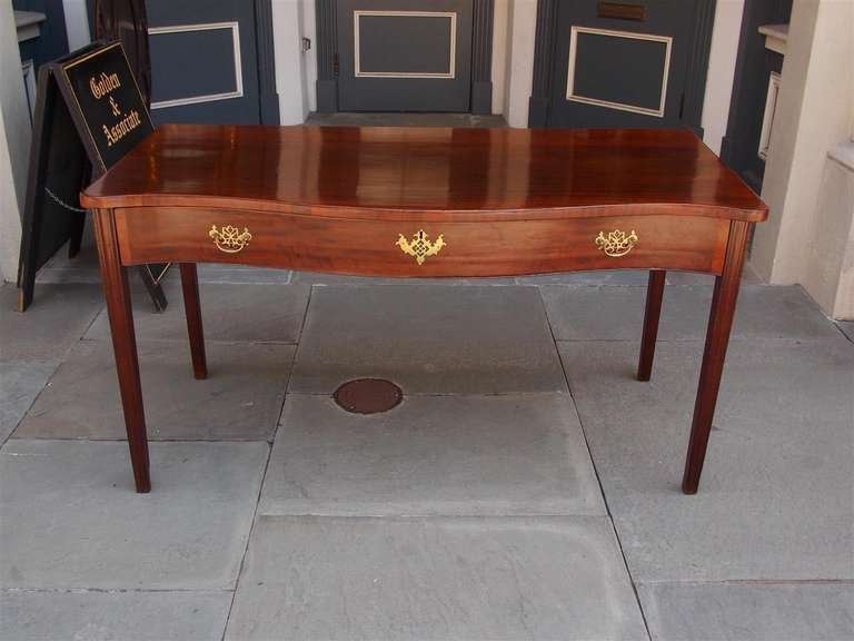 English mahogany one drawer serpentine server with original brasses , terminating on molded tapered legs.  Dealers please call for trade price. 