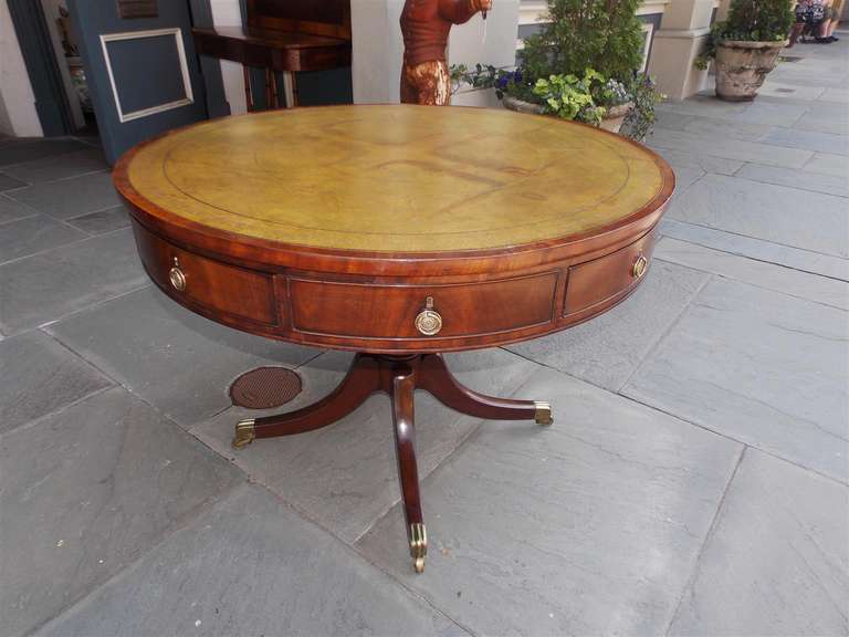 English Regency mahogany four drawer rent table with leather top, original pulls, bulbous pedestal, and terminating on saber legs with original brass casters. Late 18th Century