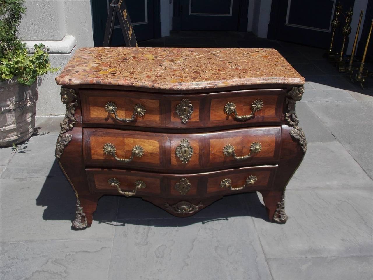 Pair of Italian zebra wood three-drawer marble top Bombay commodes with inlaid fruit wood front drawers and side panels, original ormolu mounts, escutcheons, and decorative pulls, terminating on front splayed and rear block feet, Late 19th century.