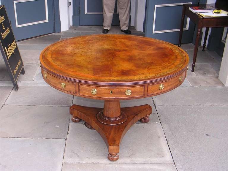 Barbados mahogany leather top four drawer rent table with a turned bulbous pedestal resting on a tripod base with original  sand box feet and brass casters. Early 19th Century