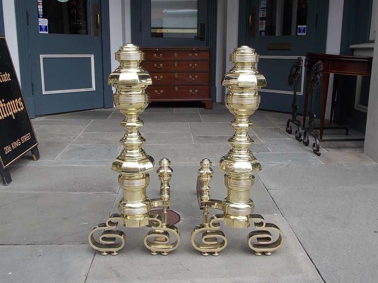 Pair of American brass monumental Empire andirons with scrolled legs and original matching log stops. Dealers please call for trade price.