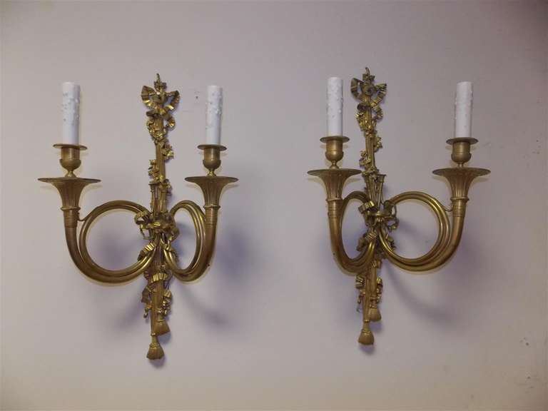 Pair of French horn gilt bronze two-arm sconces with floral and tassel motif.  Originally candle powered and has been electrified. Early 19th Century.