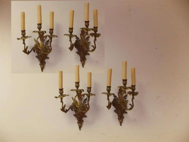 Set di quattro appliques a tre bracci in bronzo dorato francese con motivo floreale. Originariamente alimentate a candela, sono state elettrificate. Inizio del XIX secolo.