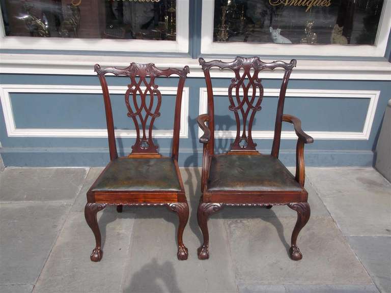 Set of Eight English Chippendale style mahogany dining chairs with acanthus carved splat back, gardrooned carved skirt, acanthus carved knee, removable leather seats, and resting on the original ball and claw feet.  Early 19th Century.  Set consist