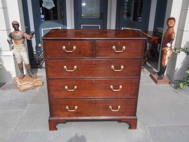 English Chippendale mahogany graduated five drawer chest with original brasses and terminating on bracket feet. Early 19th Century.