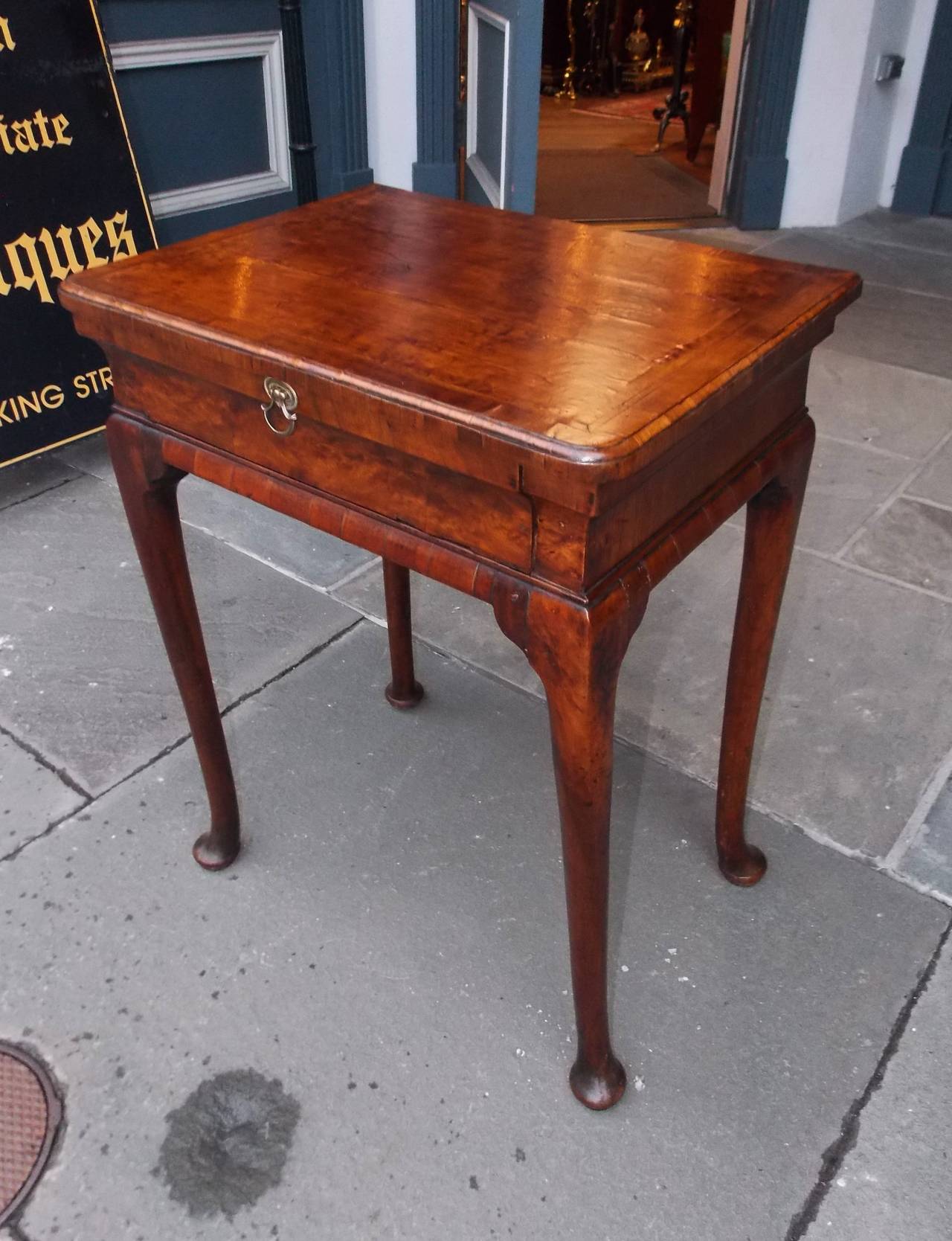 English Queen Anne walnut one-drawer side table with cross banded top, inlaid feather banding, original brass pull, and terminating on rounded tapered legs with pad feet, Early 18th century. Table is finished on all sides.
