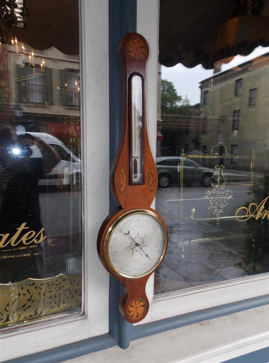 English mahogany banjo barometer with satinwood inlaid pinwheels, flanking conchs, engraved steel thermometer and hand chased barometer dial, all surrounded by an inlaid border. Barometer can be restored to working order at minimal cost. Signed by