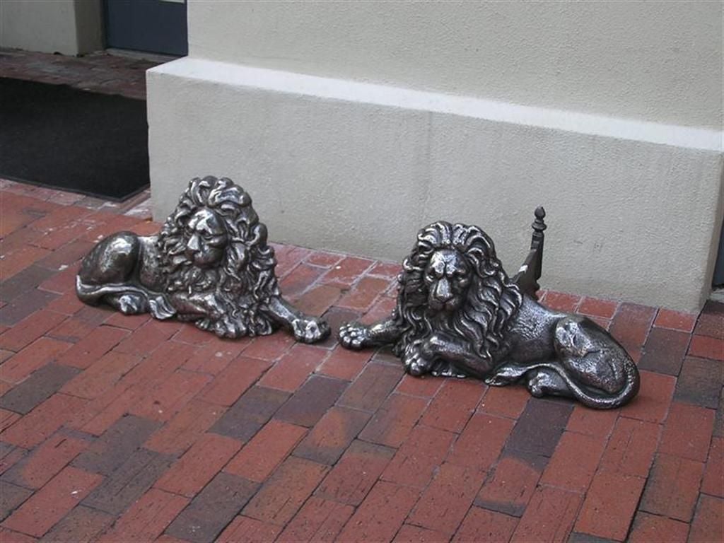 Pair of English Georgian polished cast iron  lion door stops with original supports. When aquired they were being used as andirons for the fireplace.