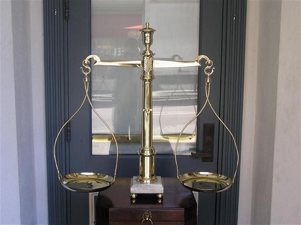 English brass scale with centered urn ,  feather pointer ,  brass pans, marble base , and terminating on brass ball feet.  All original . Early 19th Century