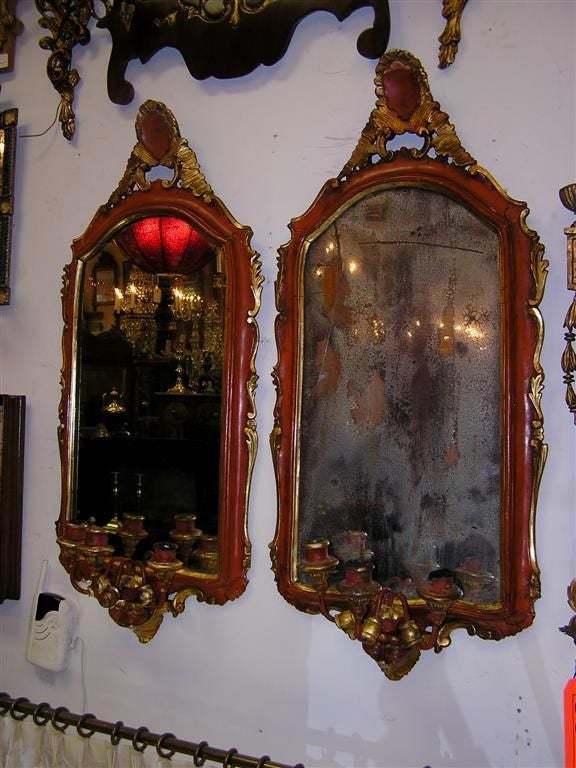 Pair of Venetian painted and gilt girandole mirrors with carved floral crest ,  gilt side carvings & the original three arm candle cluster . Mirrors retain the original glass & wood backing . Late 18th Century. 
