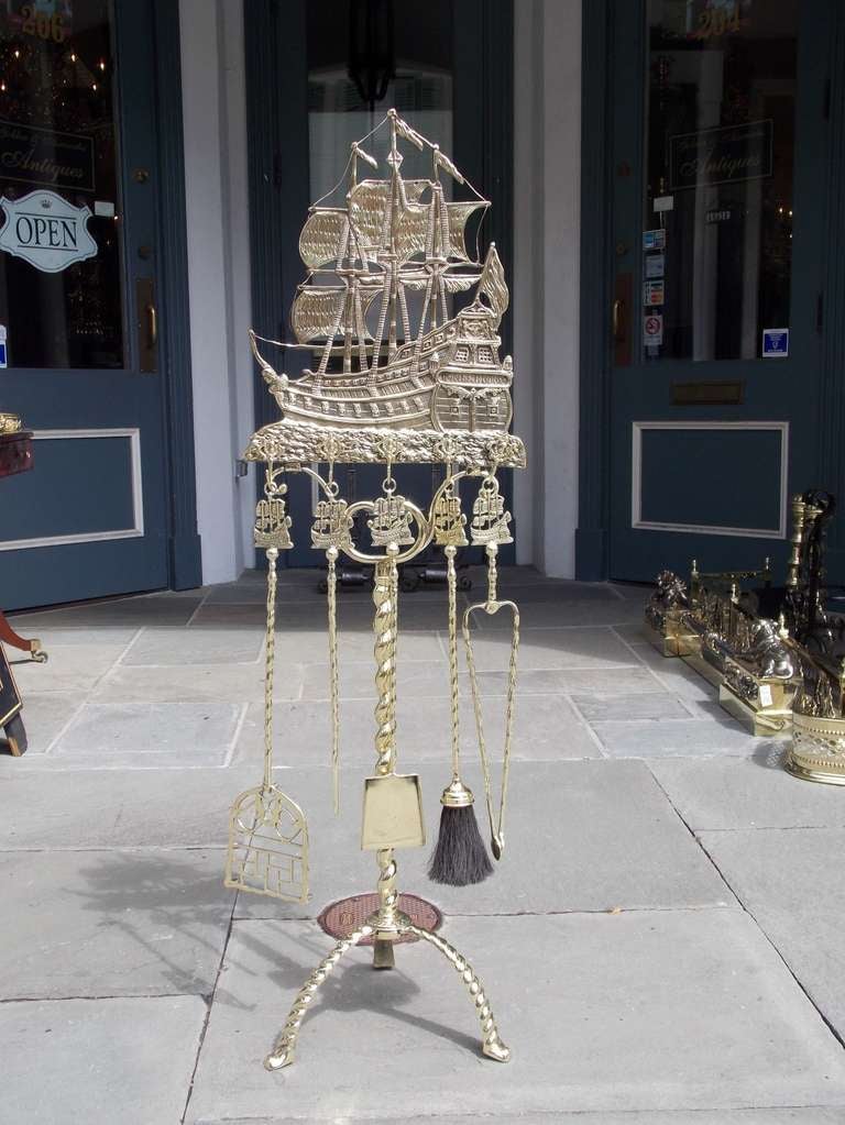 American brass Nautical fire tool set on stand with Frigate shipped named Don Fernando, matching handle five piece tools, twisted rope centered shaft, and terminating on tripod rope base. Set consist of shovel, tong, poker, trivet and brush. Early