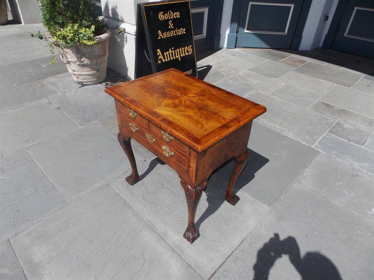 English burl walnut low boy cross banded with a tulip wood top, inlaid feather banding throughout, three drawers with original brasses and secret interior finger locks and terminating on acanthus carved knees with Spanish feet, Mid-18th Century.