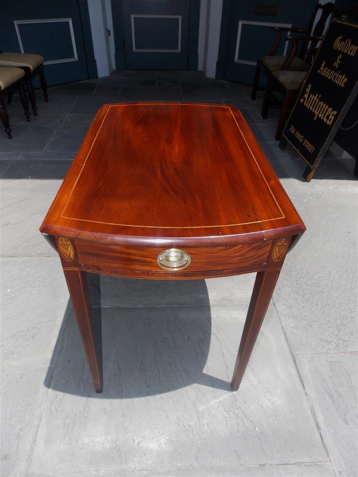 American Hepplewhite one-drawer mahogany and satinwood string inlaid drop leaf pembroke table with oak leaf and acorn pateras, original brass pull, and terminating on squared tapered cuffed legs. Table is 21