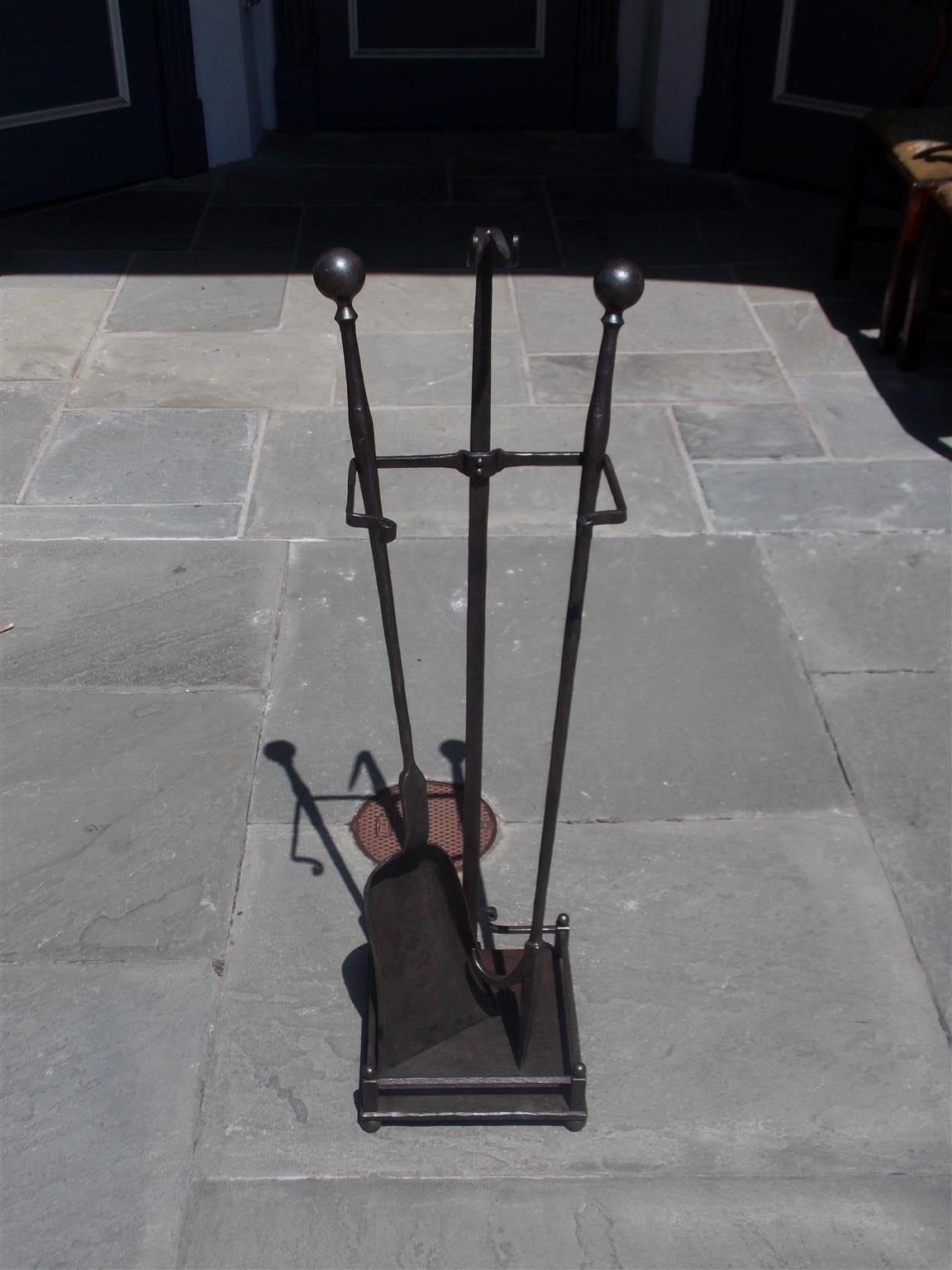 Set of American wrought iron ball top fireplace tools on stand with a squared gallery base resting on ball feet. Set is of the highest quality and consist of a poker and shovel, Mid-19th century.
