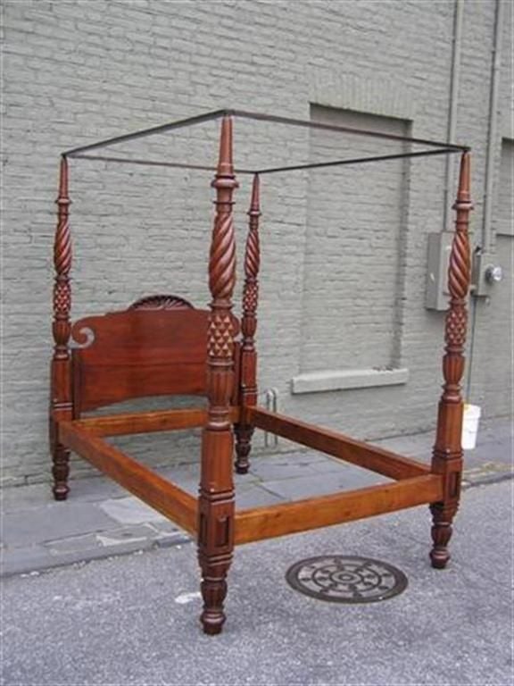 Barbados mahogany hand carved four poster tester bed with flanking scrolled sunburst head board, carved barley twist bulbous reeded posts, stylized pineapple carvings , and terminating on turned bulbous reeded legs. Early 19th Century