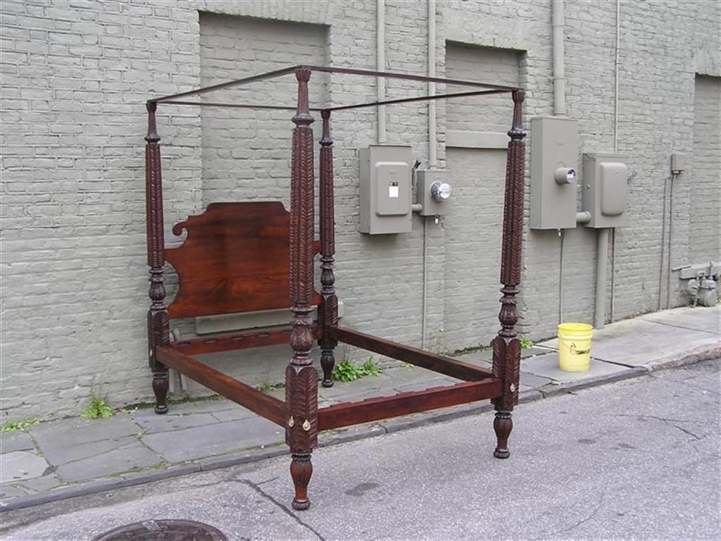 Caribbean mahogany four poster bed with intricate carved post, scrolled headboard, and ending on carved bulbous feet.