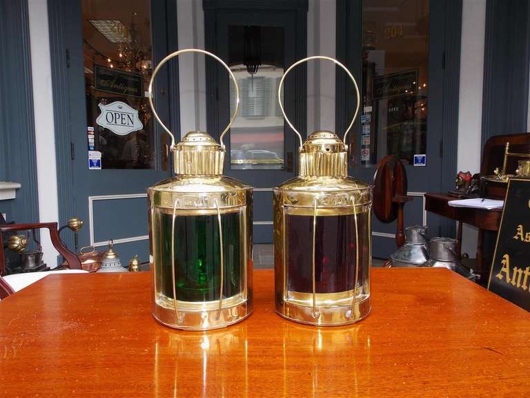 Pair of American brass port and starboard ship lanterns with original red and green colored glass lenses, vented tops, oil burners, and carrying handles.. Geo H. Mason and Co. Boston.  Early 20th Century.