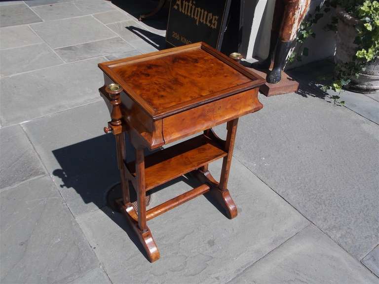 English burl walnut one drawer games table with multiple gaming pieces, adjustable flanking candle holders,  lower shelving, and terminating on chamfered scrolled legs with connecting stretcher .  Early 19th Century
