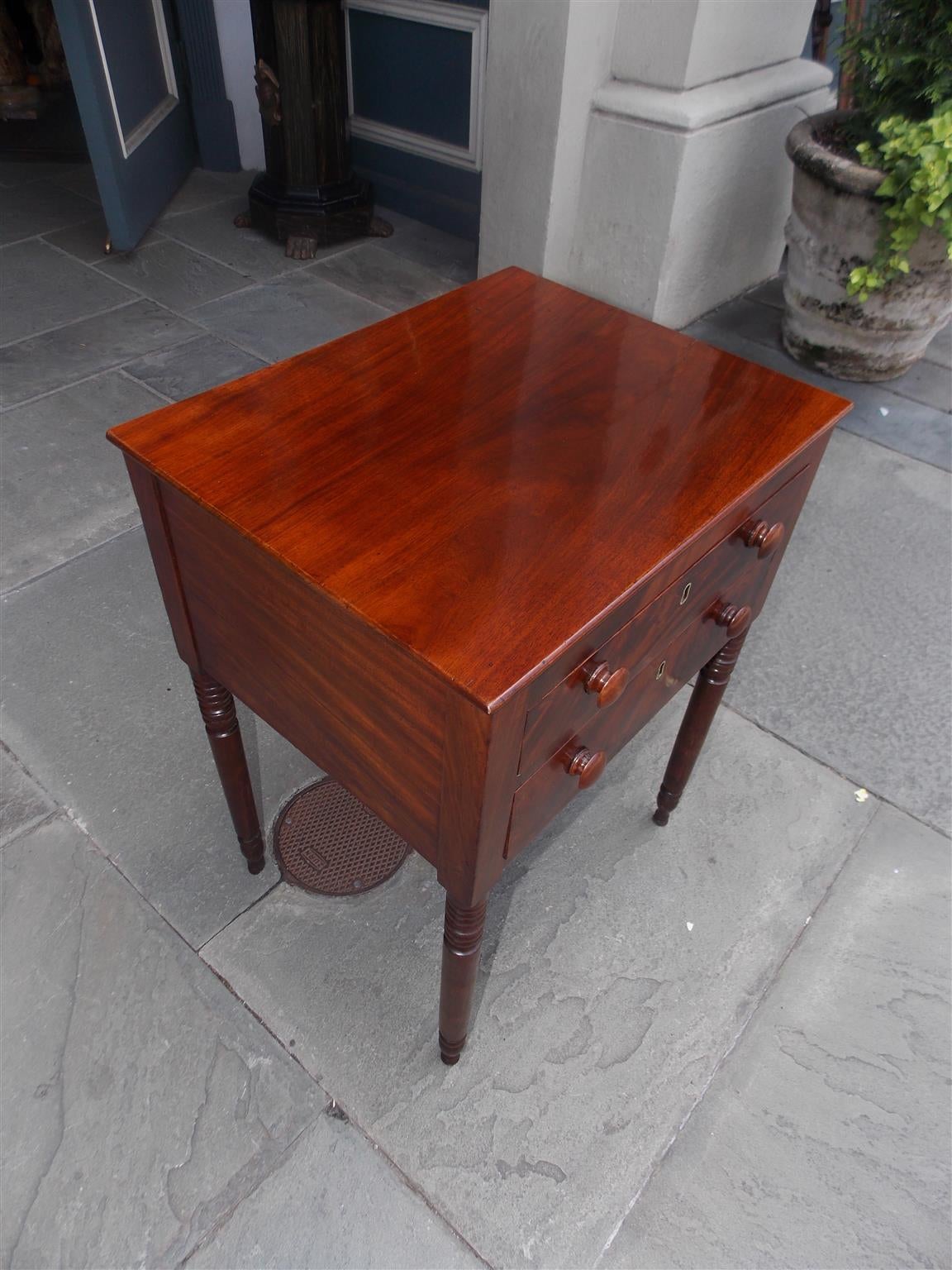 American Sheraton mahogany graduated two-drawer side table with original wooden knobs, one board top, and terminating on turned bulbous ring legs. Secondary wood is poplar, Early 19th century.