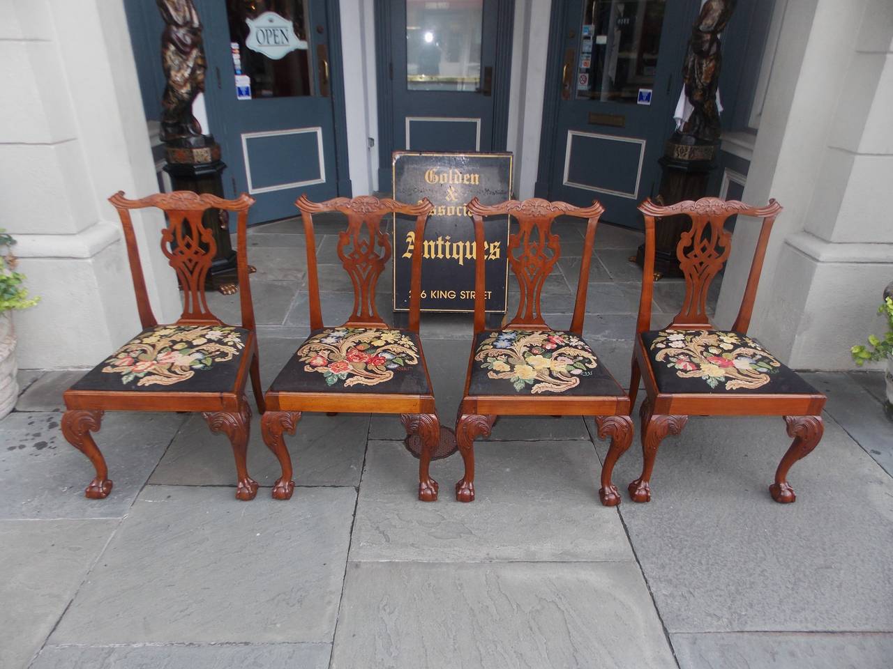 Set of four English Chippendale walnut side chairs with acanthus carved rails, splat backs, removable needle point seats, and terminating on acanthus carved knees with claw and ball feet. Late 18th century.