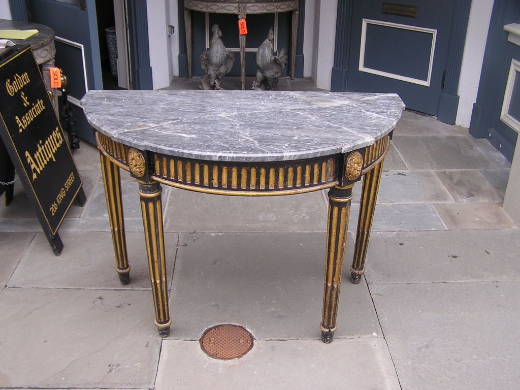 Italian painted and gilt demi lune marble top console with carved gouge gallery , corner floral medallions , & terminating on fluted turned ring legs. All original.  Late 18th Century.