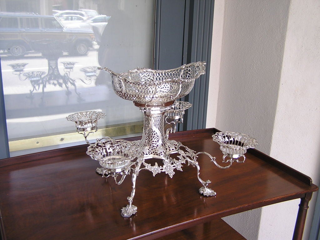 English four arm sterling epergne with center basket, grape vine motif, and ending on floral feet.