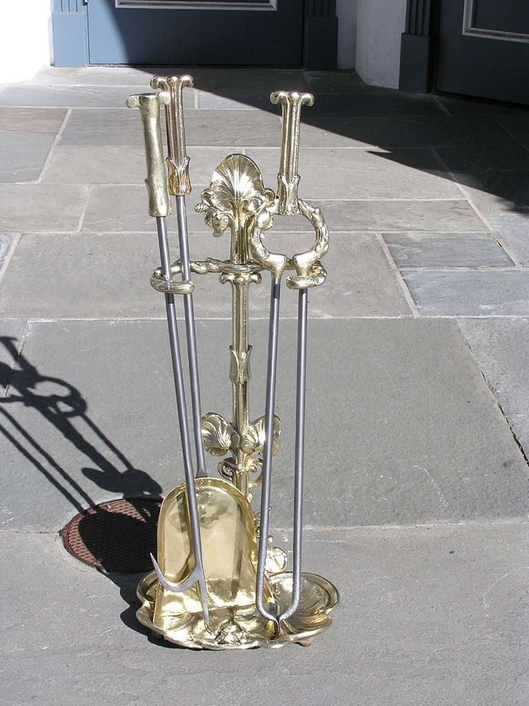 French three piece brass and polished steel fire tools on stand with decorative Lilly and frog motif. Set consist of shovel, tong, and poker. Dealers please call for trade price.