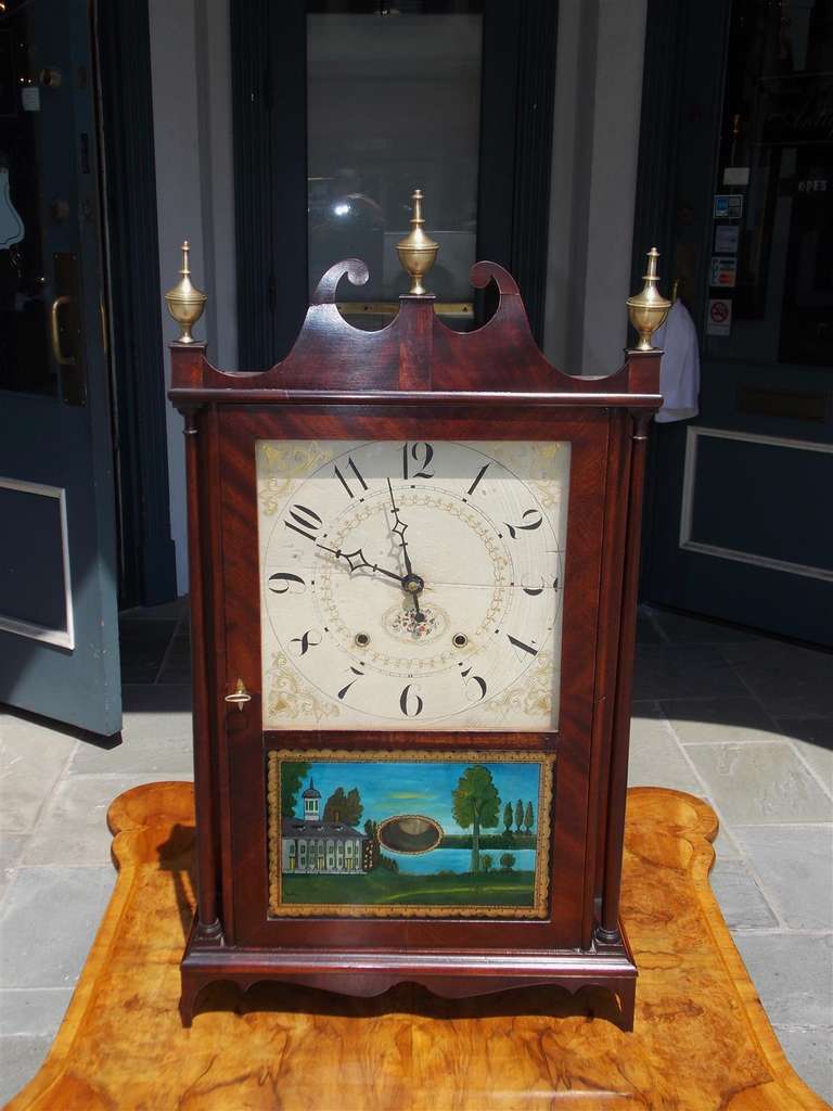 American mahogany pillar and scroll mantel clock with carved scrolled pediment, brass finials, original works, reverse painted glass of Mt. Vernon, and terminating on tapered feet. Clock has the original paper label. Eli Terry and Sons, Plymouth,