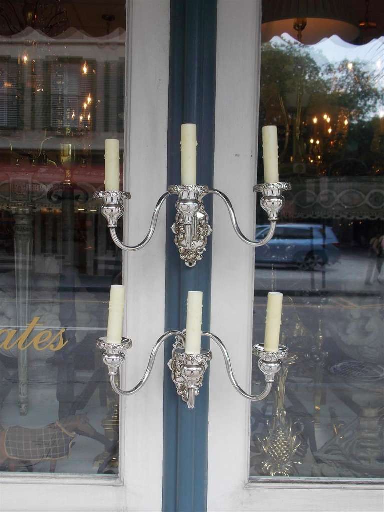 Pair of American three arm silver plated sconces with floral etched back plates and bobeches. Originally candle powered and have been electrified. Late 19th Century.