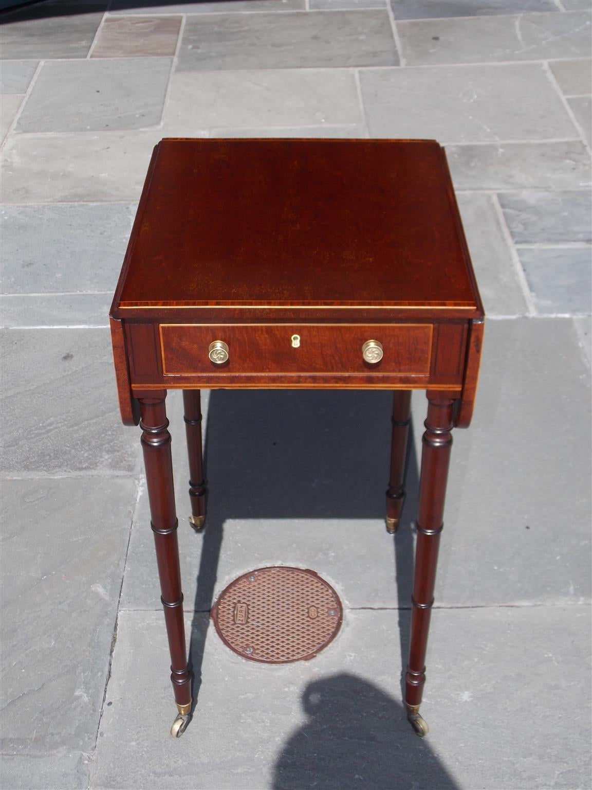 English plumb pudding mahogany drop-leaf table with tulip wood cross banding, original brasses and terminating on turned ringed legs, Late 18th century. Table is 16