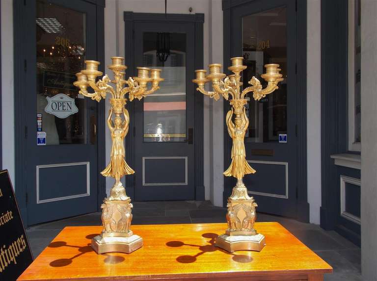 A fine pair of American angelic figural gilt bronze six light candelabra's with hand chased scrolled foliage, lambs tongue, and terminating on tripod plinth base with griffon motif. Cornelius & Co., Philadelphia. Early 19th Century.  Pair are candle