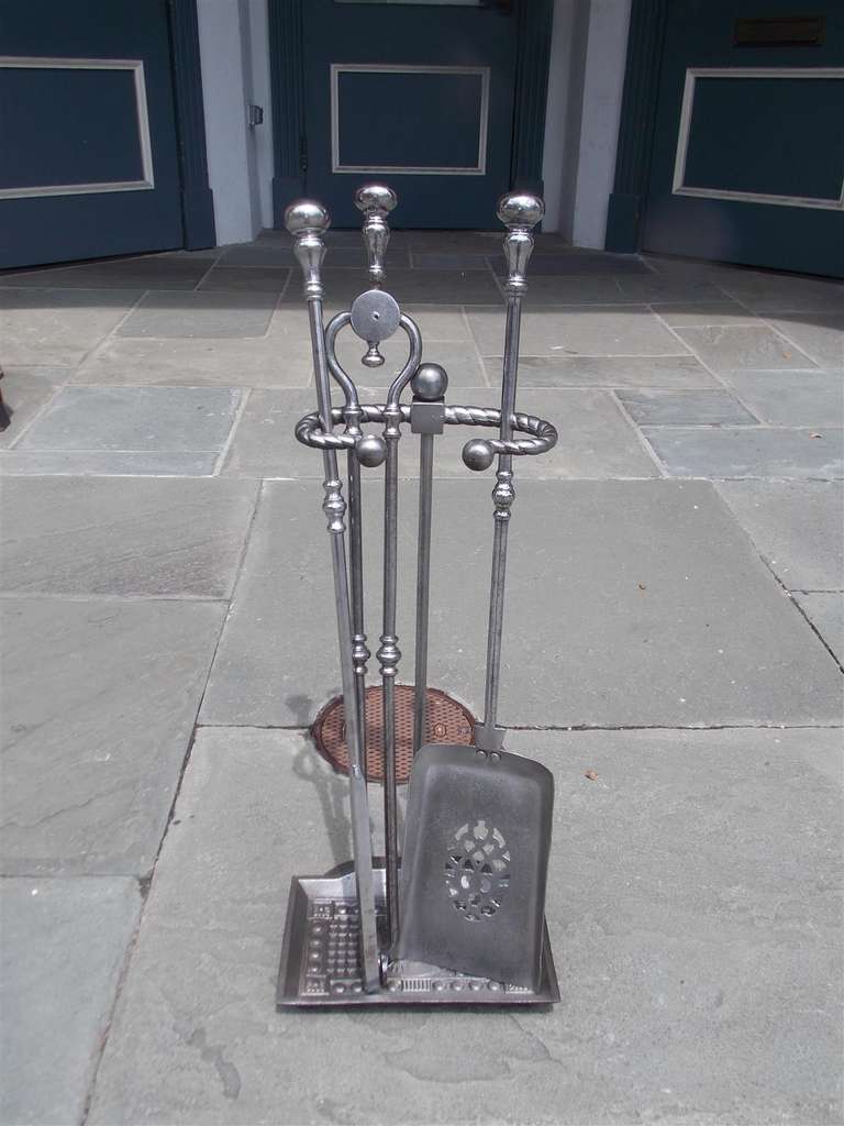 Satz englischer Werkzeuge aus poliertem Stahl auf einem Ständer mit Kugelkopfmotiv. Set bestehend aus Zange, Schaufel und Schürhaken. 19. Jahrhundert