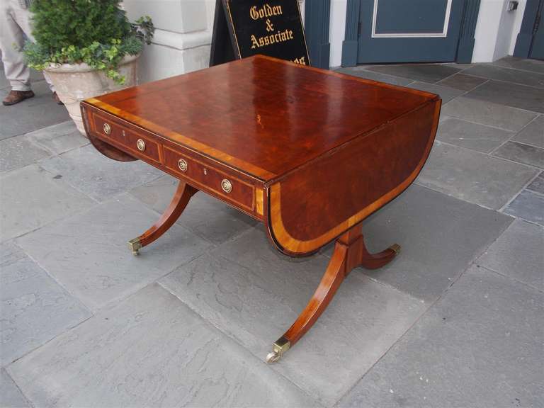 English Plum Pudding Mahogany drop leaf four drawer desk /  library table with Satinwood cross banding, and terminating original brass casters.  Circa 1780
Table is 59.5