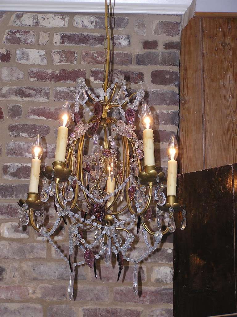 French gilt bronze and crystal five light chandelier with scrolled arms and floral bobeches, intertwined bead work, and amethyst leaf prisms.  Originally candle powered and has been electrified.  Mid 19th Century