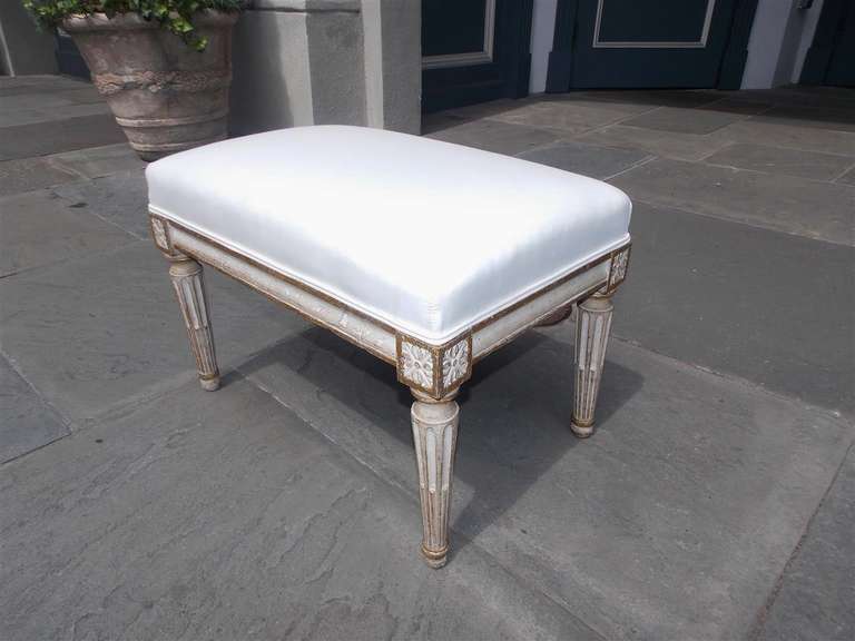 Tabouret italien peint à la main et doré, avec médaillons floraux en coin et se terminant par des pieds cannelés avec des pieds boule. Le tabouret est recouvert d'une mousseline blanche.  Début du 19ème siècle.