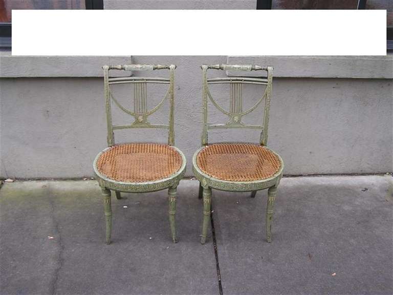 Paire d'objets français peints à la main et au pochoir  chaises latérales à dossier en lyre, avec sièges en rotin, terminées par des pieds tournés évasés.  Début du XIXe siècle