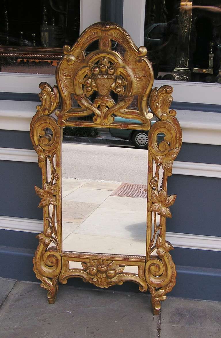 Italian carved wood and gold gilt wall mirror with centered urn, foliage and fruit motif.  Mirror retains the original glass and wood backing.  Late 18th Century