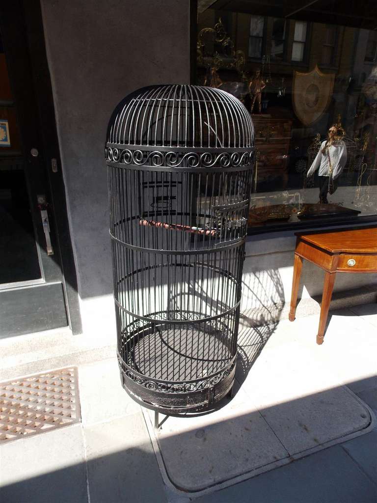 American wrought iron bird cage with scrolled motif and perch, Late 19th century