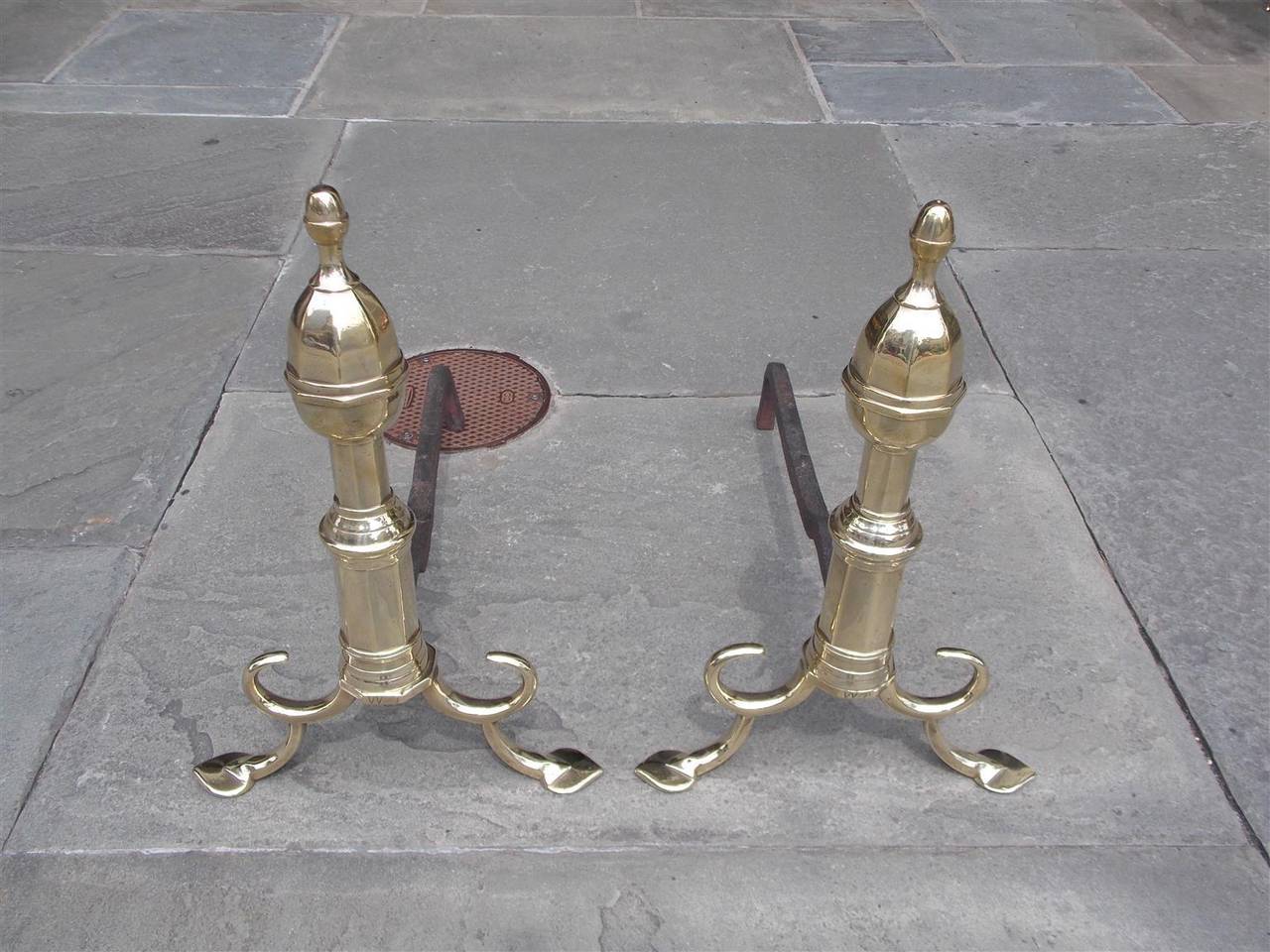 Pair of American brass acorn top finial andirons with turned faceted plinths, looped spur legs, and terminating on step back stylized penny feet, Early 19th Century, Philadelphia.