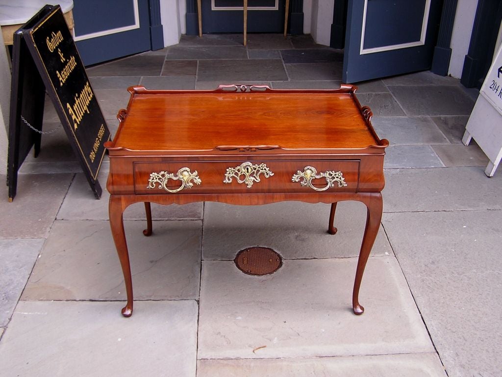 Queen Anne mahogany one drawer tea table with carved fret work gallery, original brasses, carved scalloped skirt, and terminating on cabriole legs with pad feet. Mid 18th Century