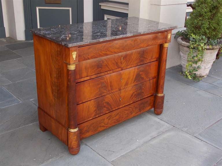 French mahogany marble top chest with graduated book matched drawers, original gilt floral ormolu mounts, and terminating on rounded block feet.  Early 19th Century