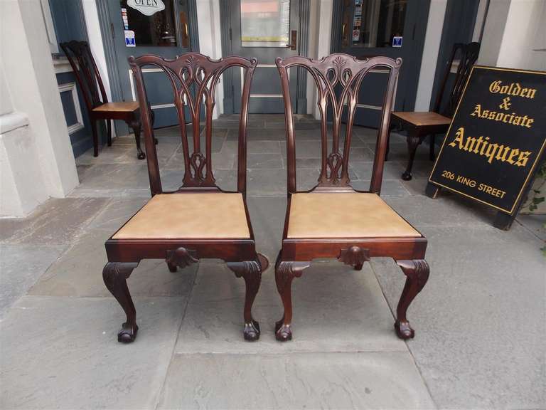 Set of four American mahogany Chippendale style side chairs with carved splat back, shell carved skirt, acanthus carved knee, and terminating on claw and ball feet. Late 19th Century. Chairs have removable upholstered seats.
