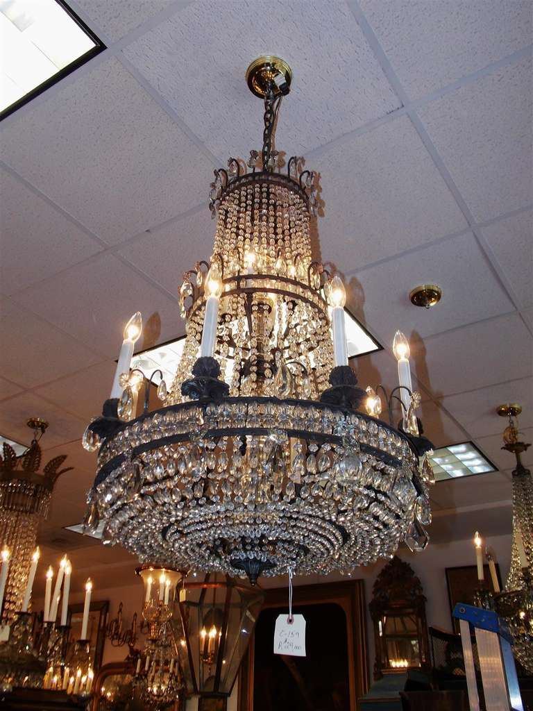 French bronze and crystal three tiered twelve light chandelier. Chandelier was originally candle powered and has been electrified. Early 19th century